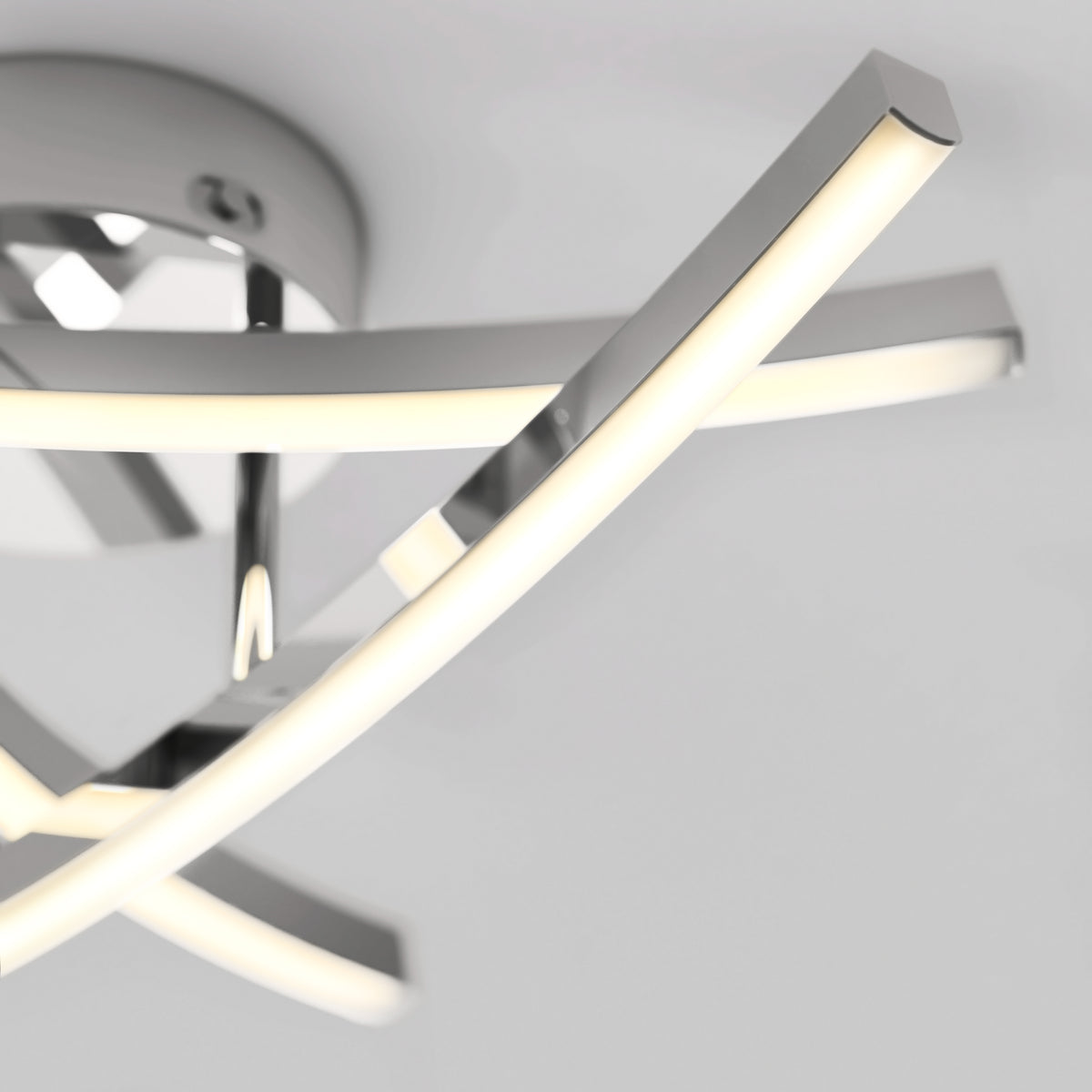 A modern ceiling light fixture with sleek, intersecting chrome bars featuring integrated LED strips, mounted on a round chrome base against a white ceiling.