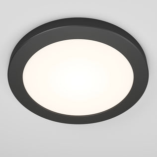 The Artika Europa Disk 7 in. LED modern flush mount light features a round design with a dark frame and bright white center, seamlessly mounted to a plain white ceiling. It offers 3 CCT options for versatile lighting.