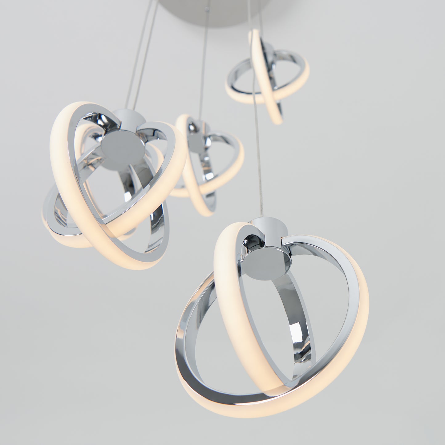 The Artika Soho modern 5-light LED pendant features five intertwined chrome rings with integrated LED lighting, elegantly suspended from the ceiling against a plain light background.