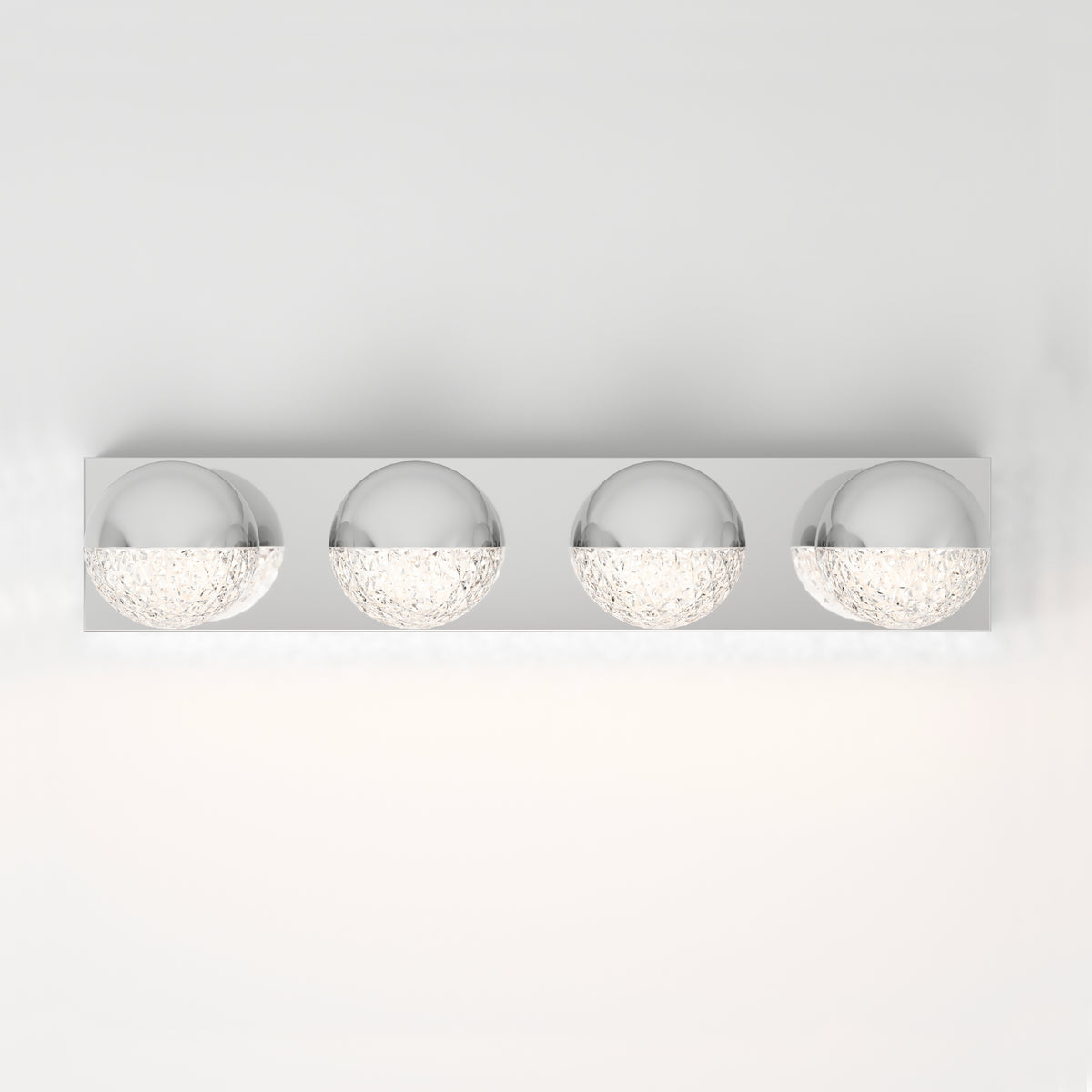 A modern wall-mounted light fixture with four spherical chrome and textured glass bulbs, evenly spaced on a rectangular metal base, against a plain white wall.