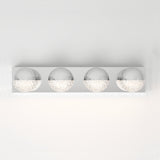 A modern wall-mounted light fixture with four spherical chrome and textured glass bulbs, evenly spaced on a rectangular metal base, against a plain white wall.