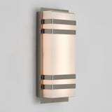 A modern wall sconce light featuring a rectangular frosted glass shade with three horizontal metal bands and a metallic backplate, mounted on a light gray wall.