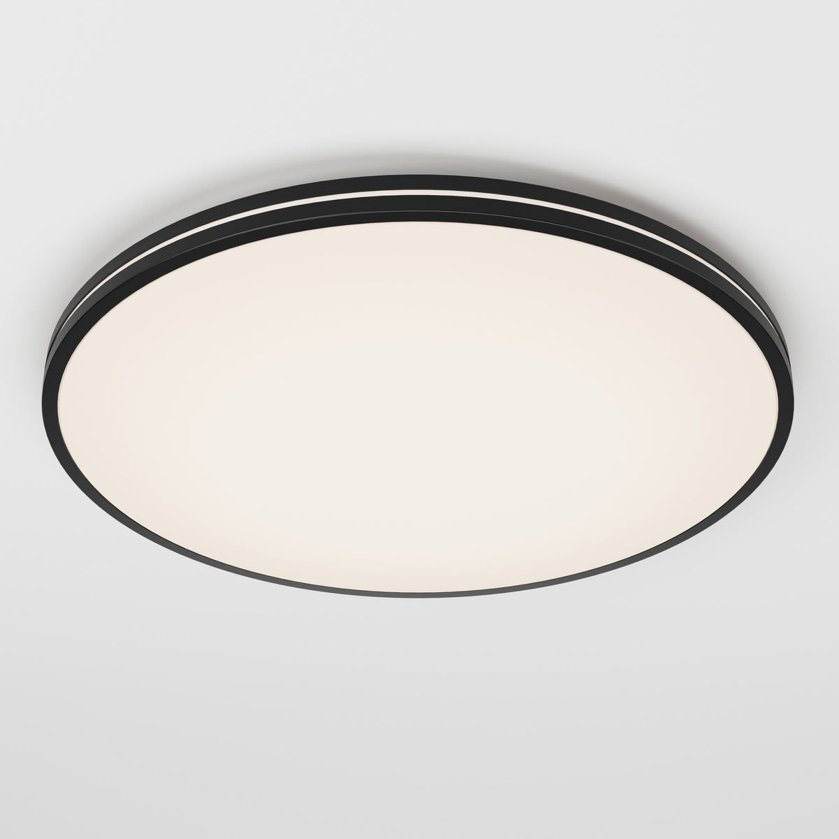 A round, modern ceiling light fixture with a black rim and a white illuminated center, mounted on a plain white ceiling.