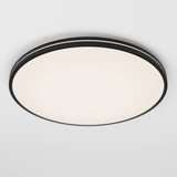 A round, modern ceiling light fixture with a black rim and a white illuminated center, mounted on a plain white ceiling.
