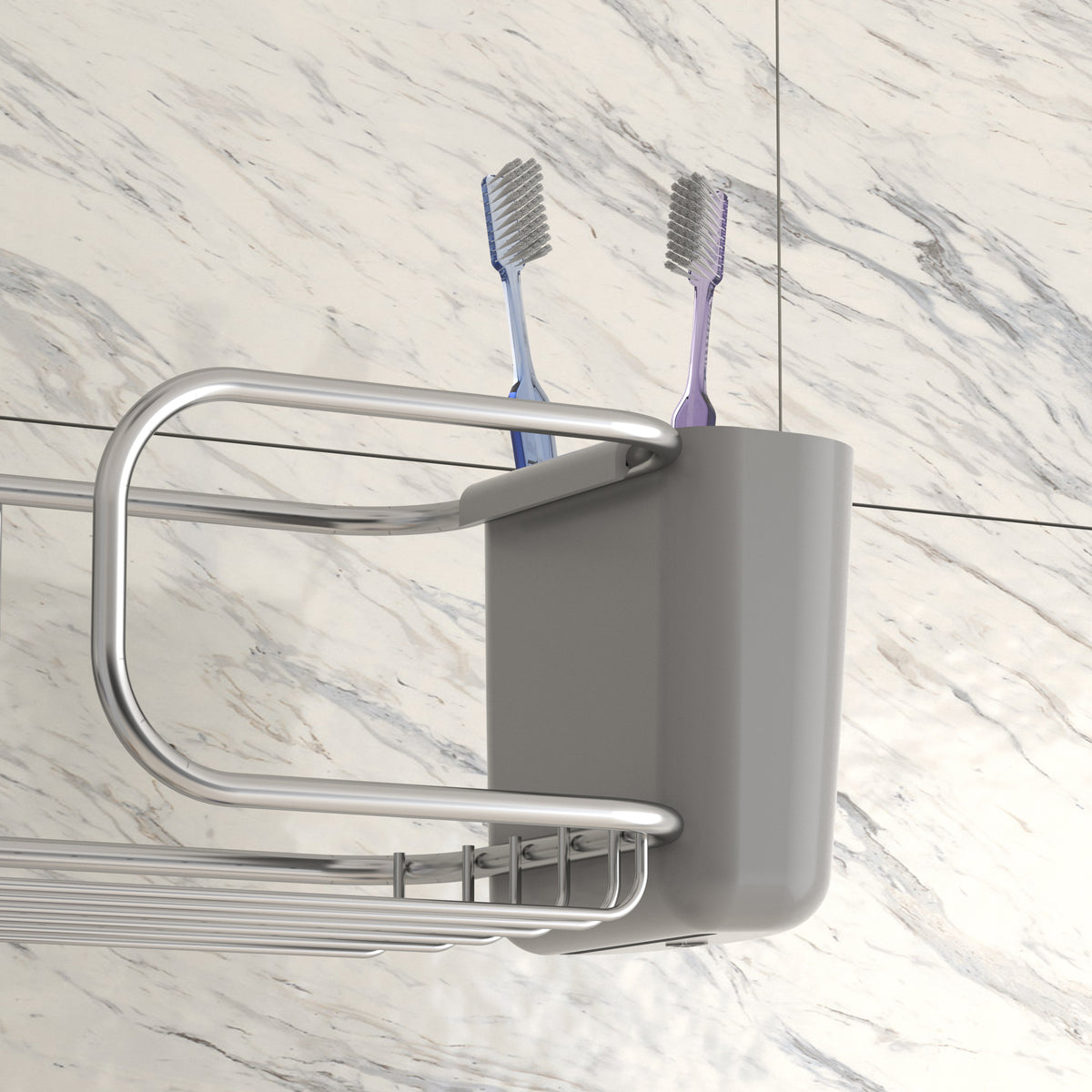 A grey toothbrush holder with two toothbrushes, one blue and one purple, sits on a metal bathroom shelf mounted against a white marble-tiled wall.