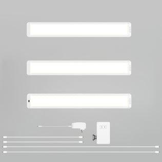 Three Artika Maestro under cabinet LED light 3CCT bars are shown horizontally above accessories: four cables, a power adapter, a switch box, and a mounting bracket, all set on a plain gray background.