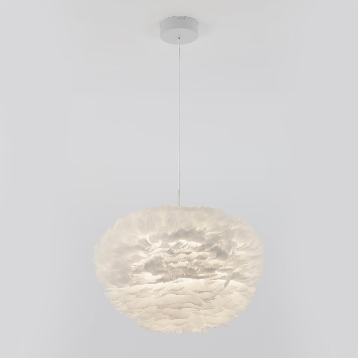 A modern pendant light fixture with a round, fluffy lampshade made of layered, white feather-like material, suspended from the ceiling by a thin, straight cord.
