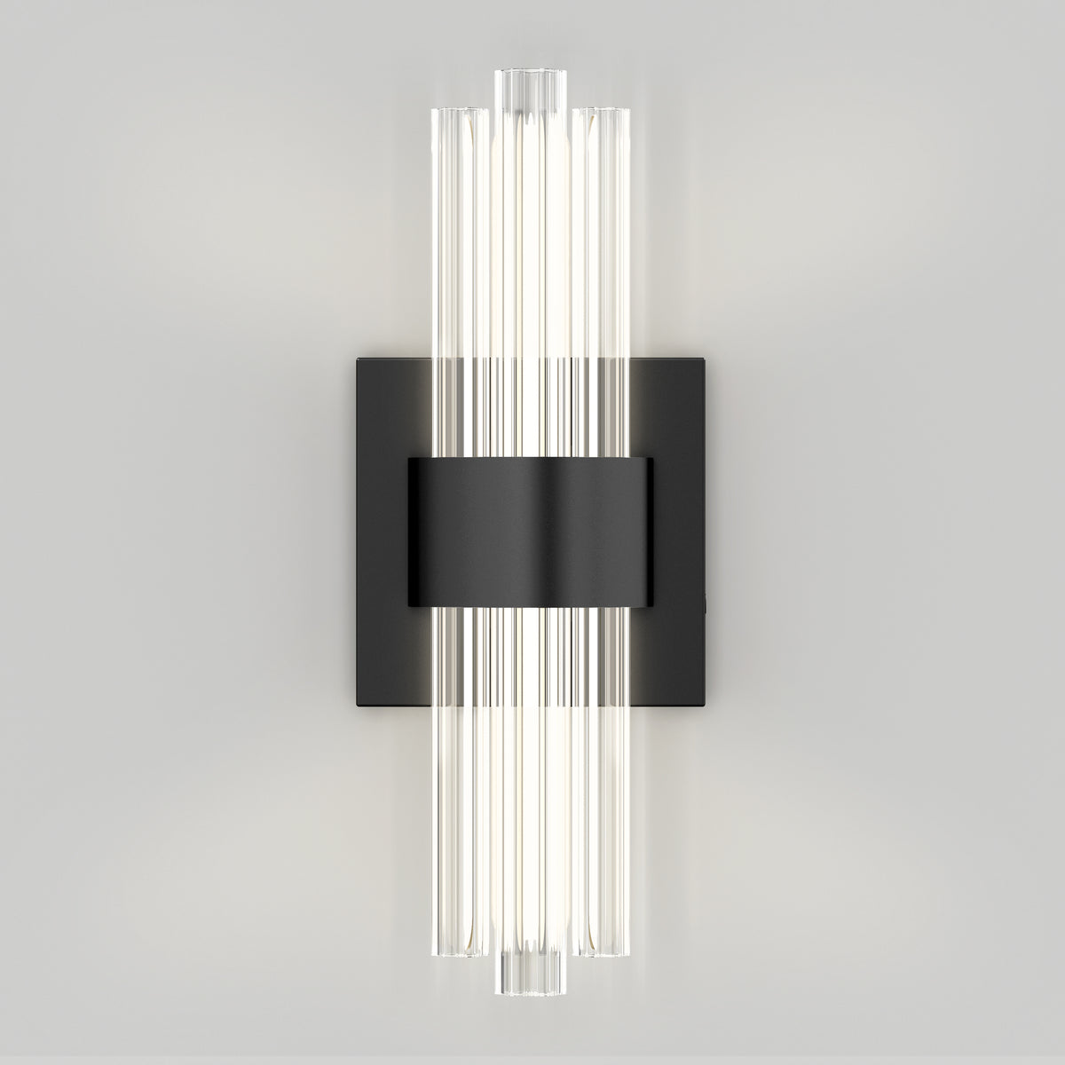 The Artika Dorado contemporary LED wall sconce features vertical cylindrical glass tubes on a rectangular black plate. With adjustable 3 CCT color temperatures, it provides a soft white glow, adding modern elegance and versatility to any light-colored wall.
