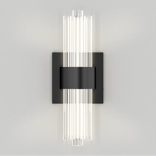 The Artika Dorado contemporary LED wall sconce features vertical cylindrical glass tubes on a rectangular black plate. With adjustable 3 CCT color temperatures, it provides a soft white glow, adding modern elegance and versatility to any light-colored wall.