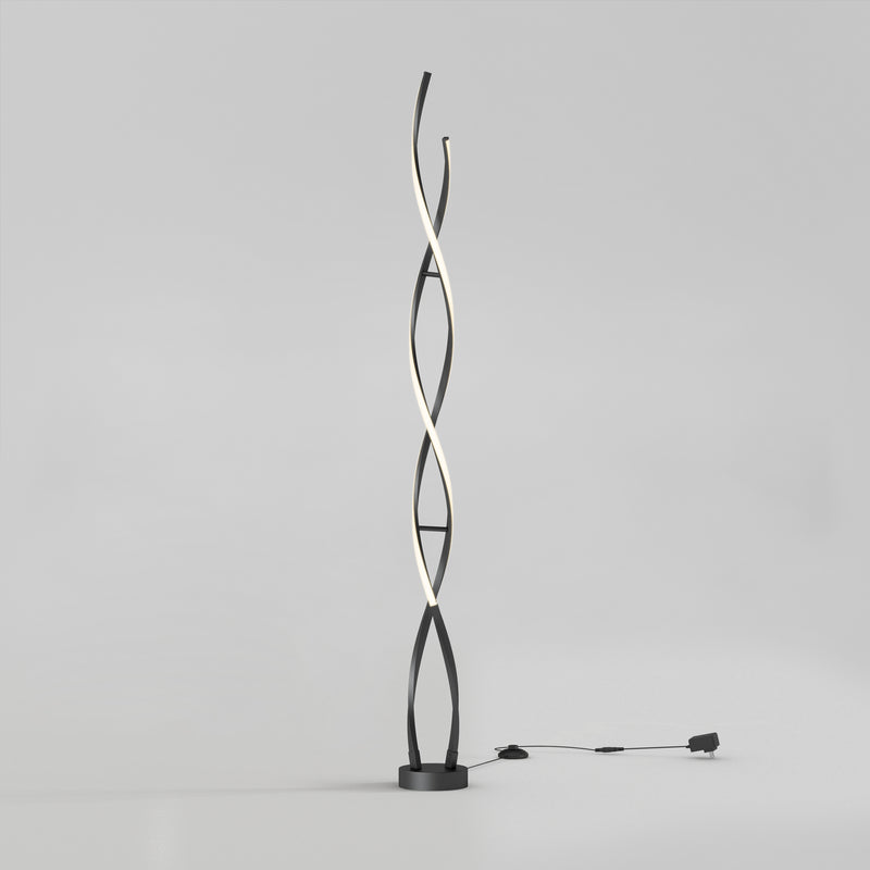 The Artika Swirl modern LED floor lamp features two black intertwining curved stems, one emitting soft white light. It stands on a round base with a visible plug-in cord, set against a plain light gray background.
