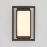 A rectangular wall sconce with a dark brown frame and a frosted, glowing inner panel, mounted on a light gray wall.