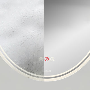 The Artika Corby 22 in. x 28 in. LED mirror with defogger shows its split design: the left side is foggy with droplets, while the right side stays clear. Illuminated touch buttons are at the bottom center for easy control of its features.