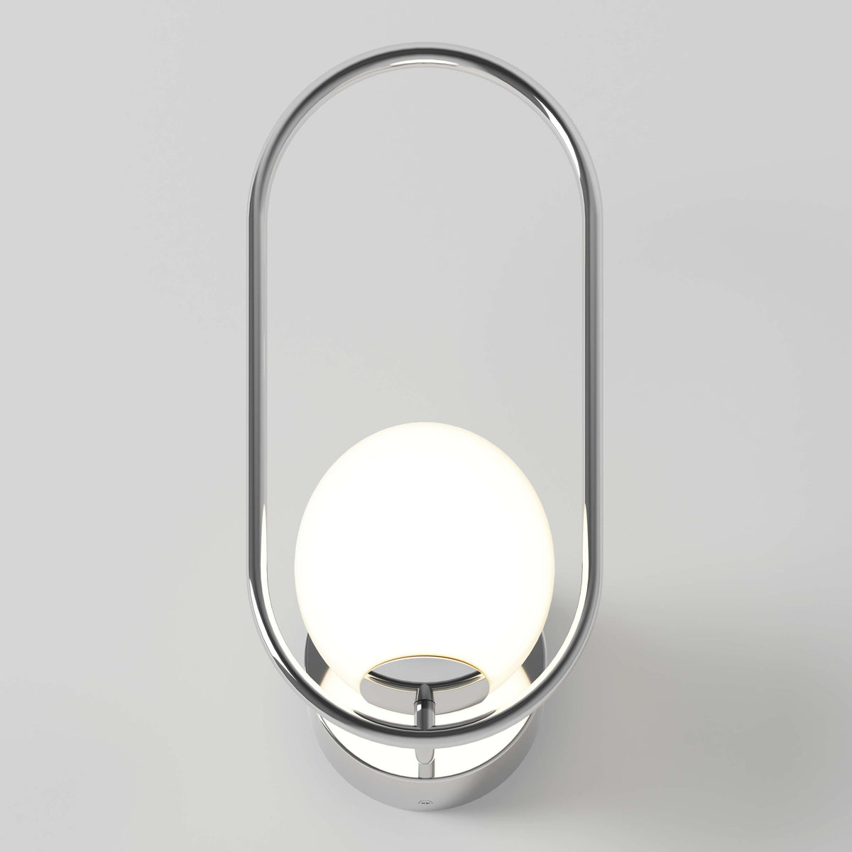The Artika Bloom LED Sconce 3 CCT features a modern chrome oval frame encircling a glowing white spherical bulb, all mounted on a round base against a light gray background.