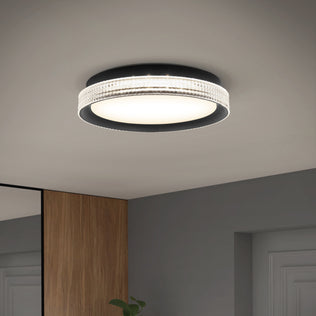 The Artika Aston 15 in. LED modern flush mount light with a frosted center and textured rim is mounted on a gray ceiling above a room with wooden and gray walls.