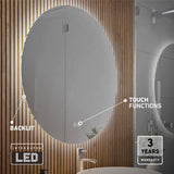 Oval backlit mirror with LED lighting and touch functions, mounted on a wooden panel wall above a sink. The image highlights the backlit feature, touch controls, and mentions a 3-year warranty.