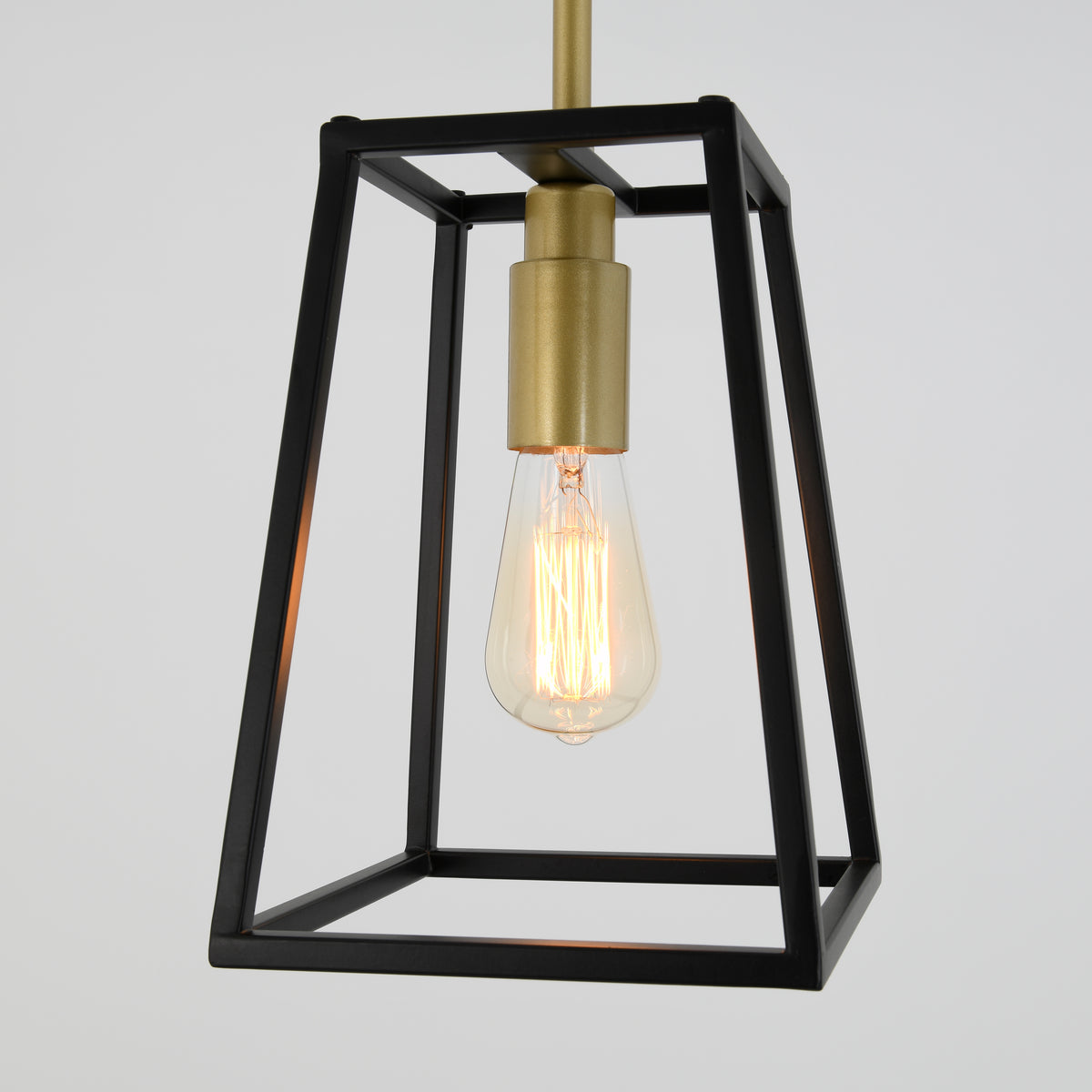 A modern pendant light fixture with a black metal geometric frame, a brass socket, and an exposed vintage-style Edison bulb, hanging against a plain white background.