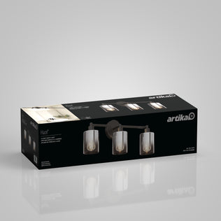The Artika Haze modern 3-light bathroom vanity light glass comes in black box packaging, showing the fixture with cylindrical glass shades and exposed bulbs on a plain gray background.