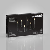 A black Artika Manchester chandelier light fixture is shown on its packaging box. The box features an image of the 8-light fixture with exposed bulbs, product details, and branding on a gray background.
