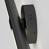 Close-up of a modern black wall-mounted light fixture with a cylindrical base and a sleek, angled light bar attached, against a plain white background.