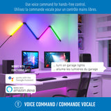 A modern workspace with a computer, colorful LED wall lights, and a smart speaker. Text promotes hands-free voice control with Google Assistant and Amazon Alexa, in English and French.