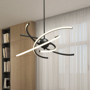 The Artika Silvio LED pendant light 3 CCT features curved, glowing LED bars around a central black sphere, hanging in a room with sheer white curtains and a built-in wooden bookshelf.