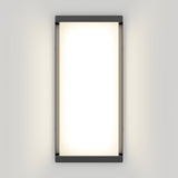 A rectangular wall-mounted light fixture with a black frame and a bright white, glowing center, emitting soft light onto a neutral-colored wall.