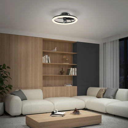 A modern living room features a beige sectional sofa, wooden coffee table, built-in shelves, tall plant, and the Artika Darren 23 in. LED modern ceiling fan with remote. Large windows are dressed with white curtains.