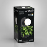 A product box for the Artika Bloomfield LED wall light. The box shows an image of the lamp, which has a round light above a section for holding green leafy plants. Product details and specifications are printed on the box.