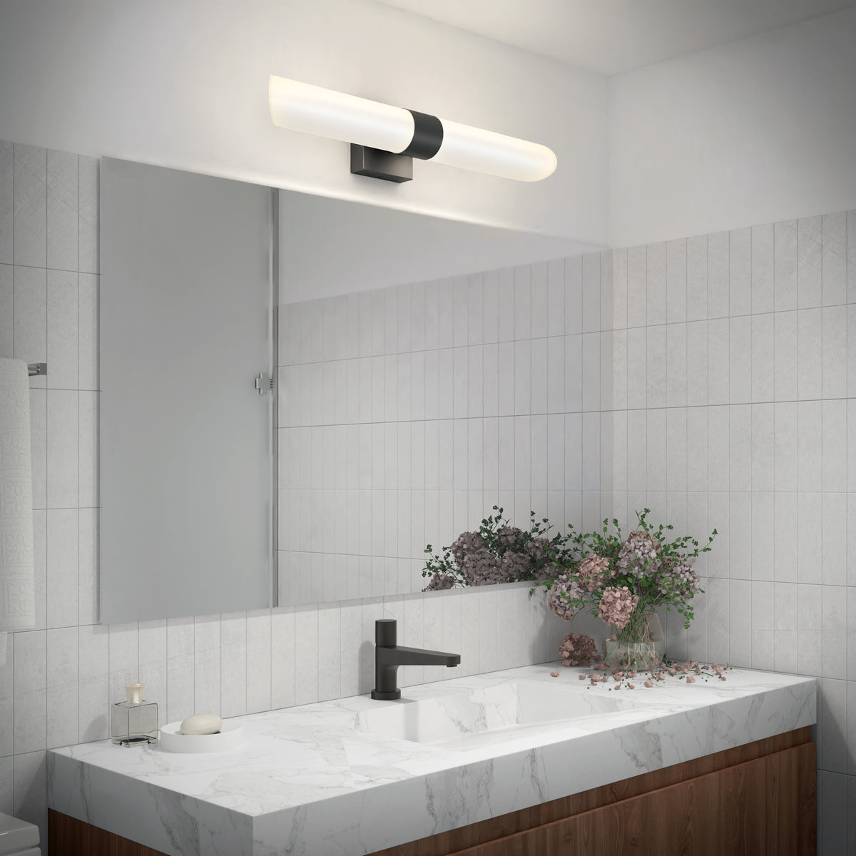 Modern bathroom with a marble sink, flowers, black faucet, large mirror, and Artika Wilton 27-in LED 5-CCT vanity light bar above.
