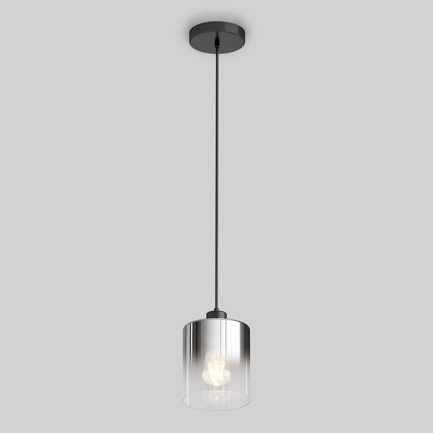 The Artika Haze pendant light glass features a cylindrical clear glass shade, black cord, and black ceiling mount. Against a plain gray background, the illuminated bulb is visible inside the modern fixture.