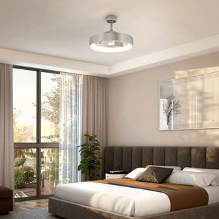 A modern bedroom with a large window, gray upholstered bed with brown and white bedding, a potted plant, and the Artika Austin 23 in. LED modern ceiling fan with remote. Framed minimalist art hangs above the bed.
