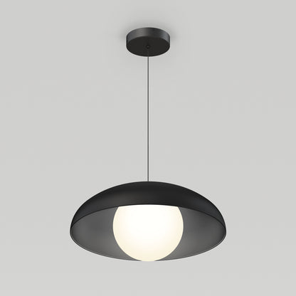 The Artika Boden LED modern mid-century pendant light 3 CCT features a round black shade and glowing white bulb, elegantly suspended by a thin black cord against a light gray background.