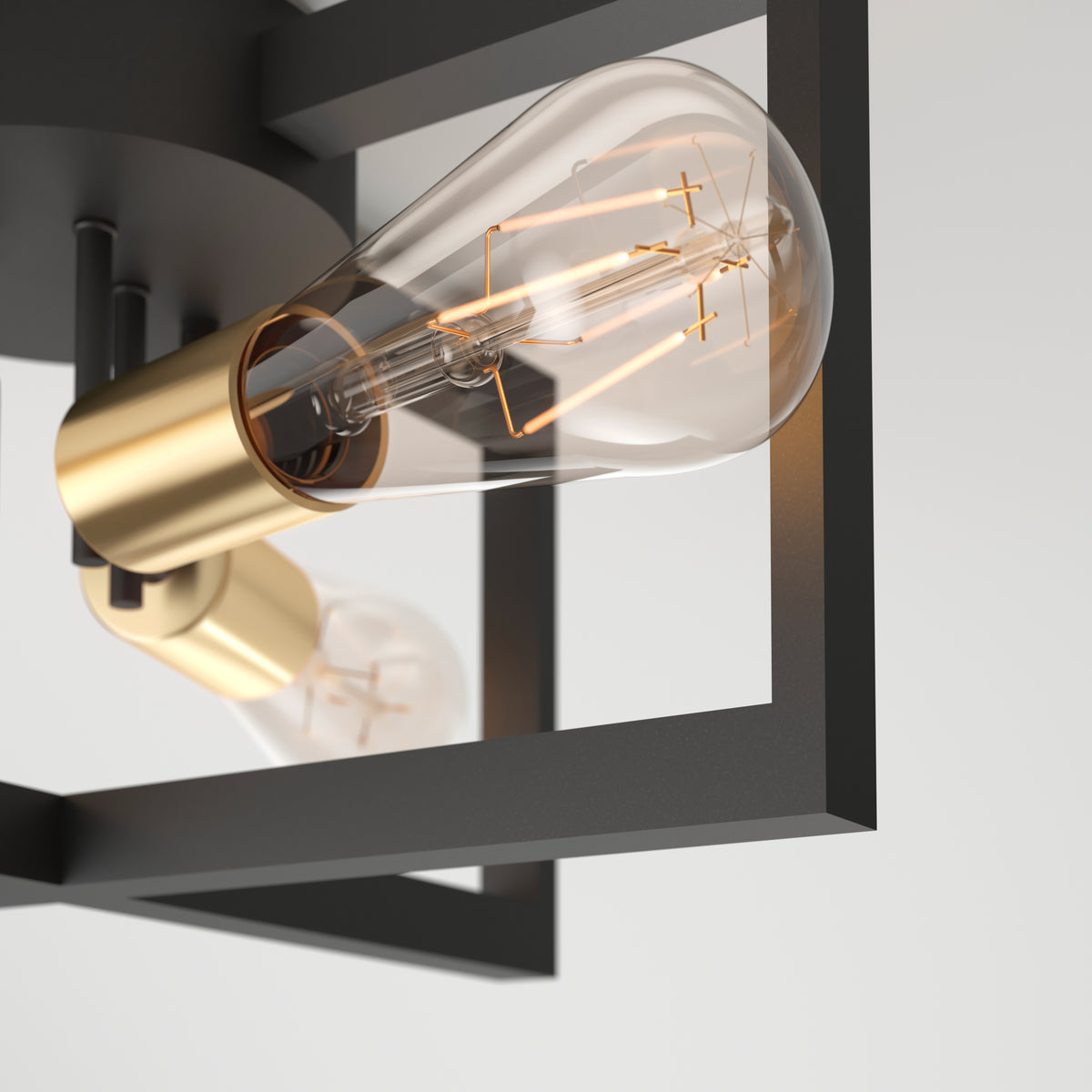 Close-up of the Artika Holt 3-light flush mount light, showcasing exposed Edison bulbs with visible filaments in gold sockets, set within a black geometric metal frame against a plain white background.