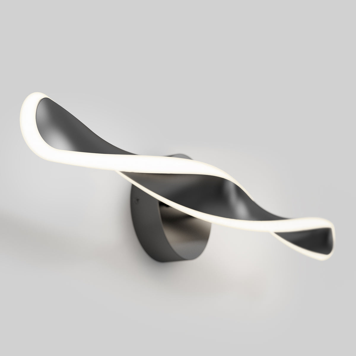 A modern wall light fixture with a twisted, ribbon-like design in black and white, emitting soft white light along its edges, mounted on a round base against a plain gray background.