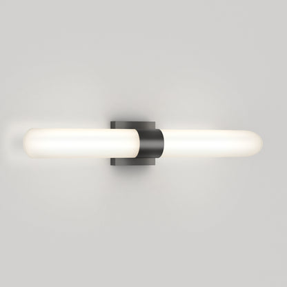 The Artika Wilton LED modern bathroom vanity light features two frosted white cylindrical tubes extending horizontally from a central black base, providing a soft glow. It offers 5 CCT options for versatile lighting.