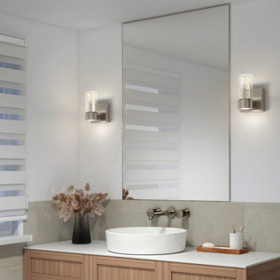 Modern bathroom with a round sink, large mirror, and Artika Essence 1-light LED vanity light accenting a wooden vanity with dried flowers.