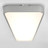 A modern, rectangular ceiling light fixture with rounded edges emits a bright, even white light against a plain white ceiling.