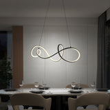 Modern dining room with a marble table set for six, beige chairs, and a sculptural, loop-shaped pendant light glowing above. Minimalist decor with neutral tones, a plant, and large windows with curtains.