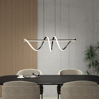 A modern dining room with a black table, four upholstered chairs, a cup and paper on the table, wood paneling, concrete walls, a potted plant in the corner, and the Artika Coda modern LED pendant light 5 CCT hanging above.