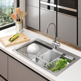 A modern kitchen sink with a flexible faucet, a white bowl on a drying rack, fresh greens in a basin, and a wooden cutting board with a corn cob next to a tin can holding kitchen utensils by a window.