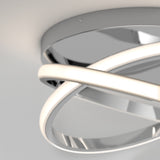 Close-up of a modern ceiling light fixture with two intersecting, curved LED light bars and a reflective circular base, mounted on a white ceiling.
