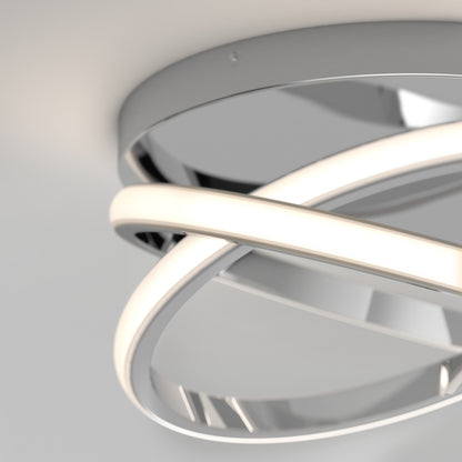 Close-up of the Artika Orbia modern LED flush mount light 3 CCT, featuring two intersecting curved LED bars and a circular metallic base, installed on a white ceiling.
