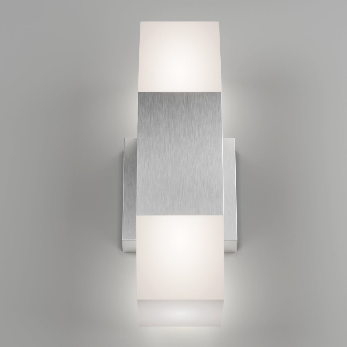 A modern wall sconce with a brushed metal rectangular center and two frosted white square light diffusers on the top and bottom, mounted on a light gray wall.