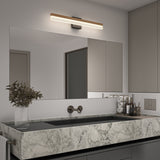 Modern bathroom with a large marble sink, wall-mounted faucet, a wide frameless mirror, a linear LED light above the mirror, beige cabinets, and a vase with dried flowers on the counter.