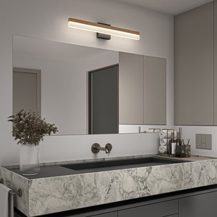 Modern bathroom with a large rectangular mirror, marble sink, wall-mounted faucet, and the Artika Neil modern LED bathroom vanity light above the mirror. A glass vase with dried flowers sits on the counter next to toiletries.