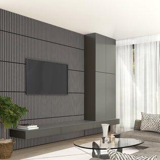 A modern living room features a wall-mounted TV on an Artika Sonolok 15.5 ft sound-absorbing wall panel kit (4-pack) accent wall, floating cabinets, a gray sofa, glass coffee table, potted plant, and sheer curtains letting in natural light.