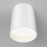 A modern, cylindrical white ceiling light fixture is mounted on a light gray ceiling, emitting a soft, even glow downward.