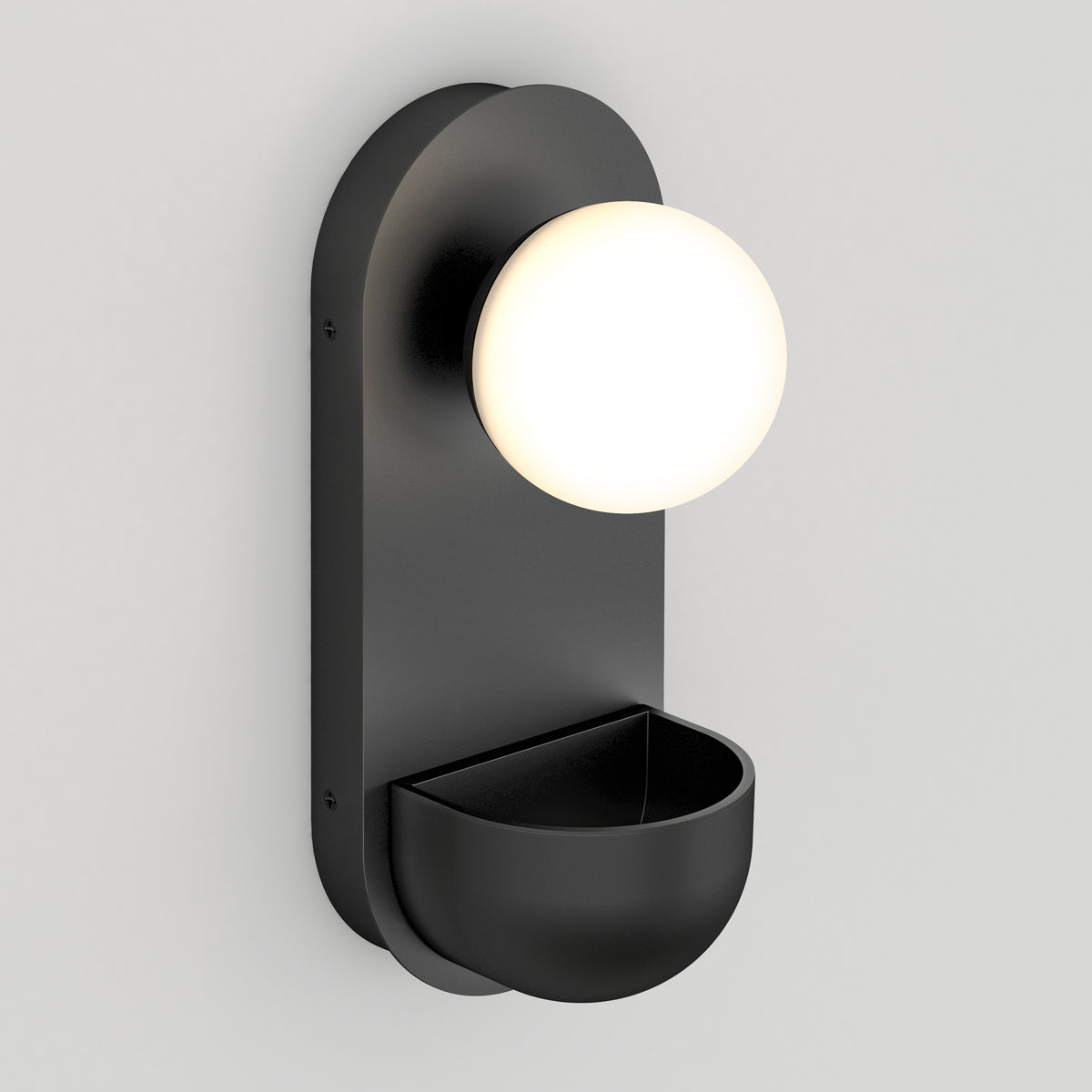 A modern black wall sconce with a round, frosted white globe light at the top and a small, bowl-shaped compartment at the bottom, mounted on a light gray wall.