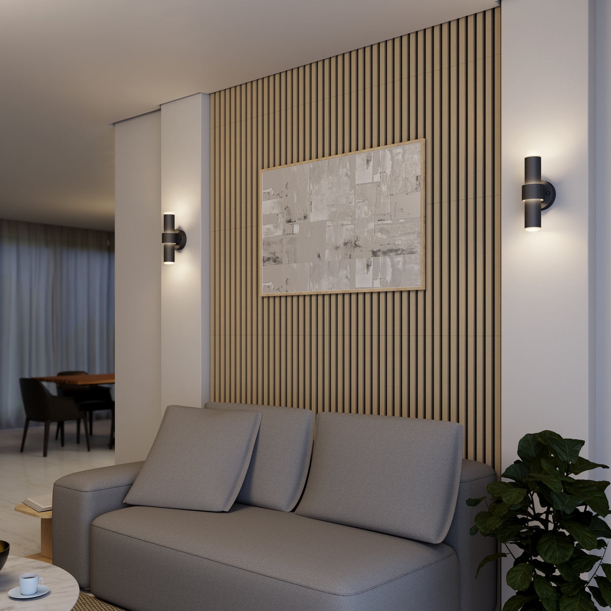 A modern living room features a gray sofa, wooden slat accent wall, abstract artwork, potted plant, and two Artika Dani modern LED indoor-outdoor wall lights (5 CCT), with a dining area visible in the background.