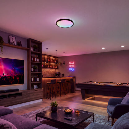 Modern living room with Artika Isara 15″ RGBIC LED light, home bar, neon sign, pool table, TV, and cozy seating.